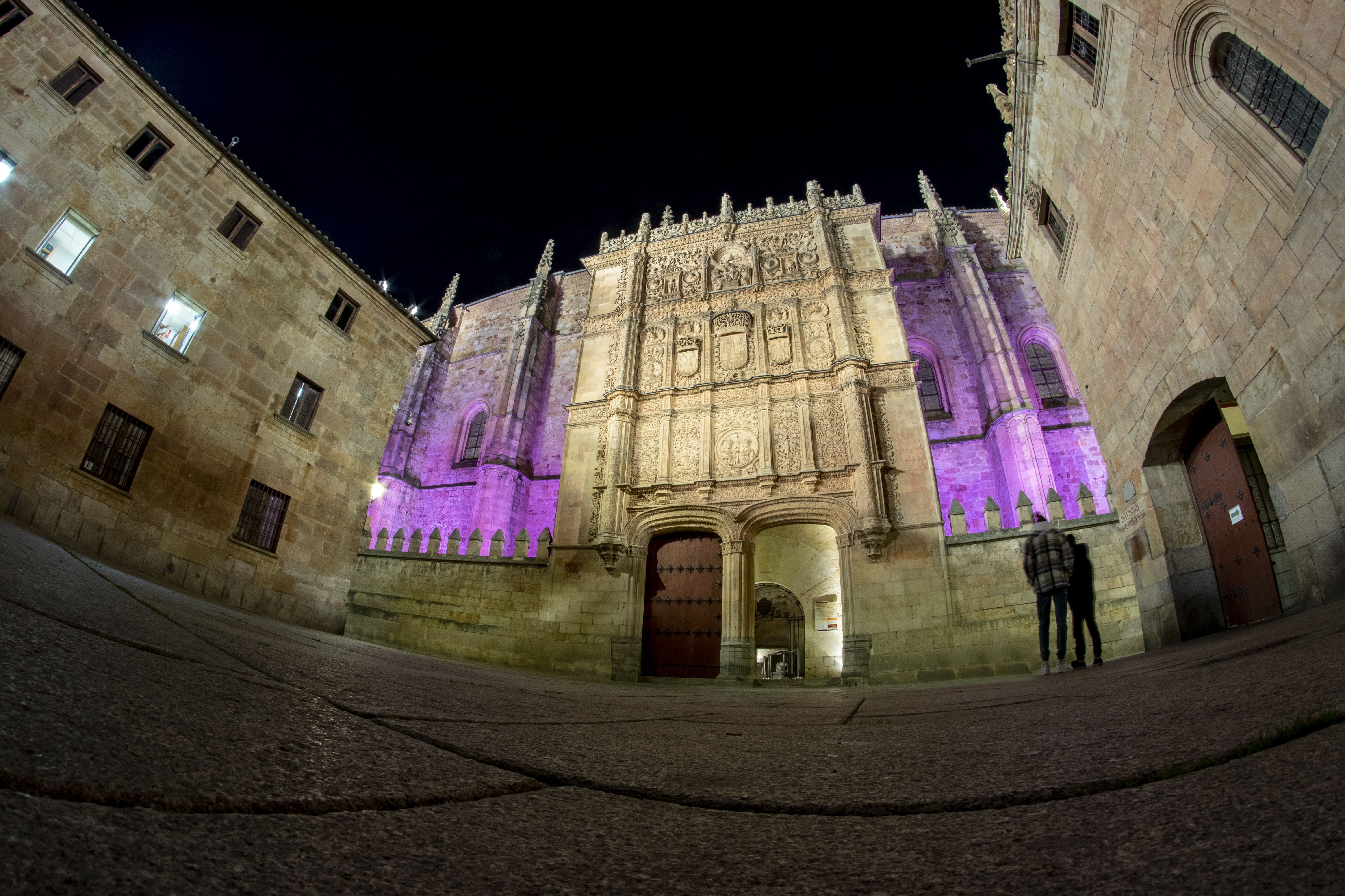 Fachada de la Universidad de Salamanca iluminada de morado